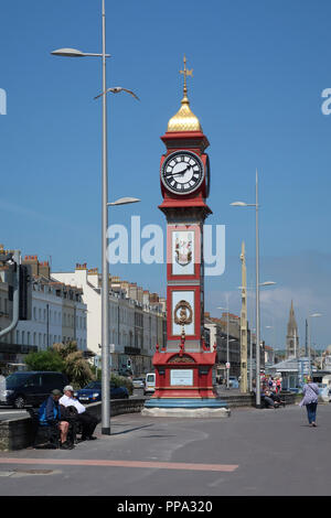 Dorchester, Dorset, England - 24. Mai 2018: Jubilee Clock Tower an einem sonnigen Tag mit strahlend blauem Himmel und Touristen zu Fuß auf dem Boulevard Stockfoto