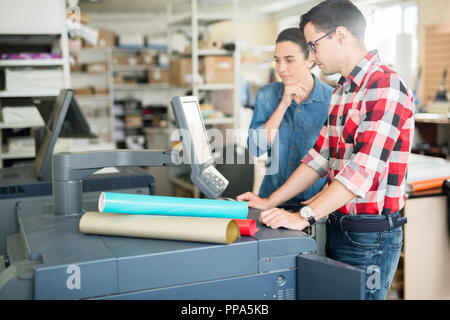 Coworking Mann und Frau mit Drucker Stockfoto