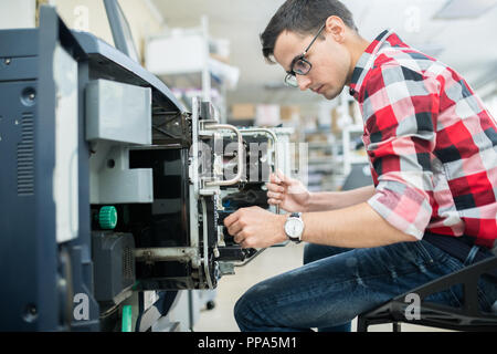 Legerer Mann arbeiten mit der Druckmaschine Stockfoto
