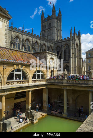 Besucher erkunden die Terrasse und großer Badewanne der römischen Bäder in Bath Abbey, in der historischen Stadt Bath, Somerset, England, UK. Stockfoto