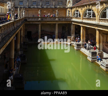 Besucher erkunden die Terrasse und großer Badewanne der Römischen Bäder, in der historischen Stadt Bath, Somerset, England, UK. Stockfoto