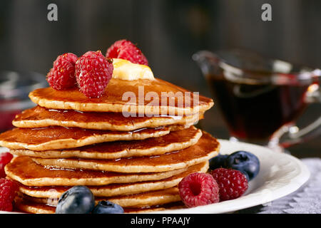 Stapel Pfannkuchen mit Beeren und Ahornsirup Stockfoto