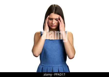 Müde Mädchen leiden unter Migräne. Junge hübsche Frau, die ihre Tempel berühren mit geschlossenen Augen wegen der starken Kopfschmerzen, weißen Hintergrund. Weibliche Kranke Stockfoto
