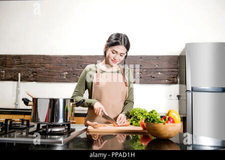 Hübsche Asiatin ist die Zubereitung von Speisen in der Küche Stockfoto