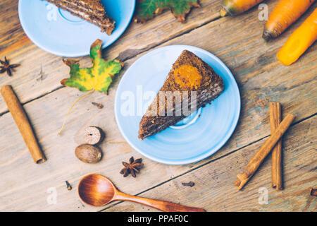 Karottenkuchen (hausgemachte Desserts) Cinnamon Sticks whith und mit Gewürzen auf hölzernen Hintergrund eingerichtet. Stockfoto