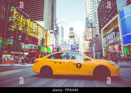 NEW YORK - September 2, 2018: Yellow cab Geschwindigkeiten durch den Times Square der belebten touristischen Schnittpunkt von Neon Kunst und Kommerz und ist eine Ikone Straße von Stockfoto