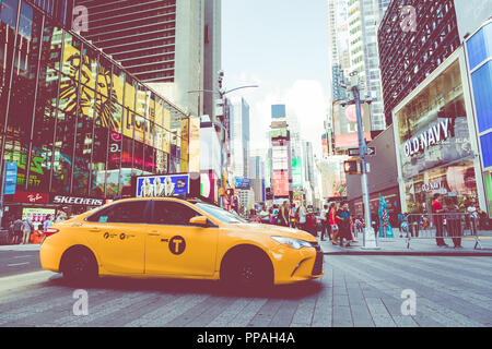 NEW YORK - September 2, 2018: Yellow cab Geschwindigkeiten durch den Times Square der belebten touristischen Schnittpunkt von Neon Kunst und Kommerz und ist eine Ikone Straße von Stockfoto