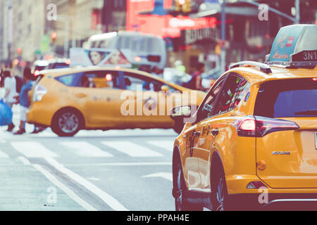 NEW YORK - September 2, 2018: Yellow cab Geschwindigkeiten durch den Times Square der belebten touristischen Schnittpunkt von Neon Kunst und Kommerz und ist eine Ikone Straße von Stockfoto