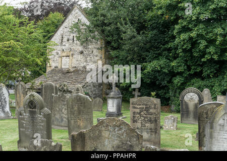 Alte verwitterte Grabsteine auf dem Friedhof, Kirche der Heiligen Dreifaltigkeit, Ashford im Wasser, Derbyshire, Großbritannien Stockfoto
