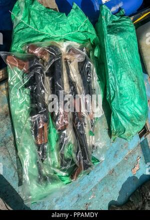 Golf von Aden (Aug. 28, 2018) eine Tüte mit AK-47 automatische Gewehre aus einem Skiff durch die geführte Anti-raketen-Zerstörer USS Jason Dunham (DDG109) besuchen, Board, Durchsuchung und Beschlagnahme Team belegt beim Leiten der Maritime Security Operations. Die statuslose Skiff wurde gefunden, eine Sendung von über 1.000 illegale Waffen. Dunham ist in die USA 5 Flotte Bereich der Maßnahmen zur Unterstützung der Marine im Einsatz für die Stabilität und Sicherheit in der Region zu gewährleisten und verbindet das Mittelmeer und den Pazifischen Raum durch den westlichen Indischen Ozean und drei strategischen Punkten ersticken. Stockfoto