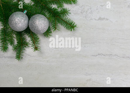 Zwei silberne Ornamente auf Ästen in der oberen linken Ecke mit Fichte Platz kopieren Stockfoto