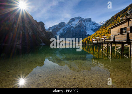 Boot Haus mit Sonne und Croda del Becco, Seekofel, im See im Herbst reflektiert, Pragser See, Lago di Braies, Pragser Wildsee, Provinz Bozen, Bozen Stockfoto