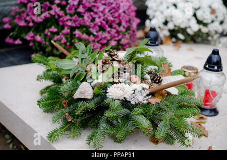 Dekoration aus trockenen bunte Blumen auf dem Friedhof an Allerheiligen im Herbst Stockfoto