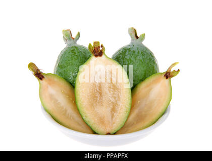 Ganze, halbe und viertel Scheiben frische Ananas guave Obst in einer kleinen weißen Schale auf weißem Hintergrund. Stockfoto