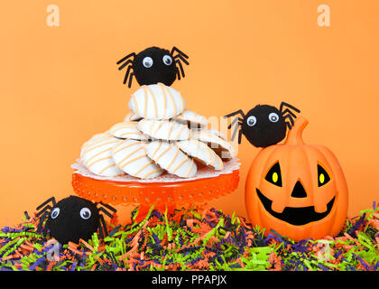 Orange Sockel mit pumpkin Muffin top Kuchen Cookies Frosted, Orange, Schwarz und Grün zerrissenes Papier unter Jack-o-Lantern und Fuzzy google Auge spinnen Stockfoto