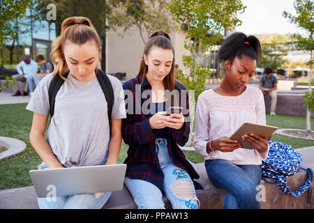 Weibliche High School Schüler mit digitalen Geräten im Freien während der Aussparung Stockfoto