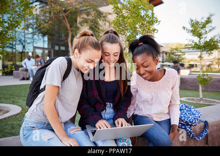 Weibliche High School Schüler mit digitalen Geräten im Freien während der Aussparung Stockfoto