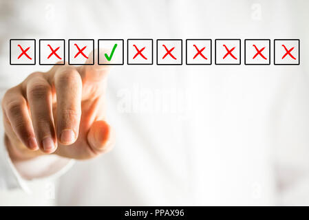Mann, der Auswahl der ausschließlich grüne Häkchen Kontrollkästchen aus einer Zeile mehrere Kisten mit roten Kreuze auf eine virtuelle Schnittstelle oder Bildschirm in einem konzeptionellen Stockfoto