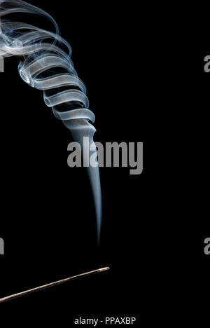 Räucherstäbchen Rauch- und Strudel auf schwarzem Hintergrund Stockfoto