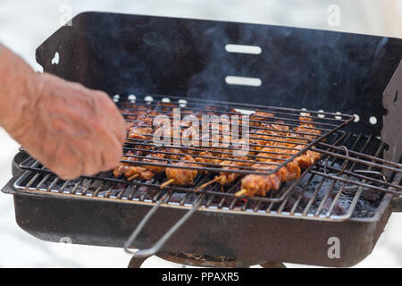 Sammeln shish Hühnerteile vom Holzkohlengrill. Stockfoto
