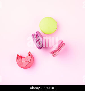 Rosa, Violett und Grün macarons auf rosa Hintergrund. Ansicht von oben. Stockfoto