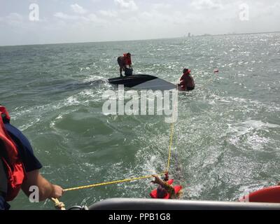 Eine Station Galveston 45-Fuß-Antwort Boot - Medium Crew rettet drei Männer aus einem sinkenden Schiff in der Nähe in der Nähe von Galveston, Texas Jan. 13, 2018. Alle drei Männer wurden die Schwimmwesten von der Küstenwache boot Besatzung vor ihrer Rettung. Stockfoto