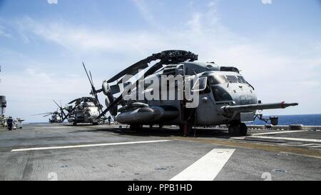 MINDANAO SEA-US-Marines mit Marine Medium Tiltrotor Squadron (VMM) 166 verstärkt, 13 Marine Expeditionary Unit (MEU) und U.S. Navy Segler mit der Essex Amphibious Ready Group (ARG), bereiten CH-53E Super Hengste von VMM-166 für den Start an Bord des Wasp-Klasse amphibisches Schiff USS Essex (LL 2) während des Such- und Rettungsmaßnahmen für eine fehlende Marine am 13. MEU während einer planmäßigen Einsatz der Essex ARG und 13. MEU, 12. August 2018. Das Essex ARG/13 MEU ist derzeit auf dem Siebten Flotte Bereich der Operationen eingesetzt. Stockfoto