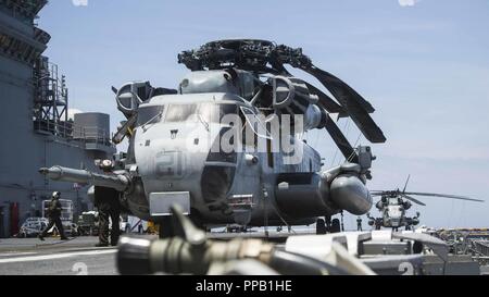 MINDANAO SEA-US-Marines mit Marine Medium Tiltrotor Squadron (VMM) 166 verstärkt, 13 Marine Expeditionary Unit (MEU) und U.S. Navy Segler mit der Essex Amphibious Ready Group (ARG), bereiten CH-53E Super Hengste von VMM-166 für den Start an Bord des Wasp-Klasse amphibisches Schiff USS Essex (LL 2), während der Such- und Rettungsmaßnahmen für eine fehlende Marine am 13. MEU während einer planmäßigen Einsatz der Essex ARG und 13. MEU, 12. August 2018. Das Essex ARG/13 MEU ist derzeit auf dem Siebten Flotte Bereich der Operationen eingesetzt. Stockfoto