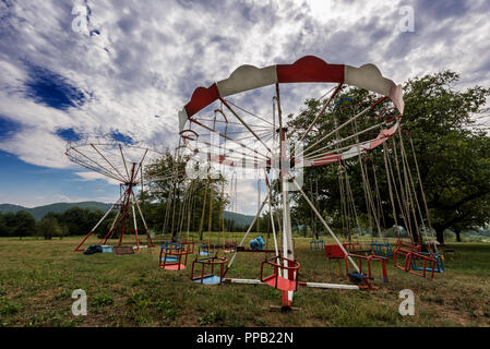 Alten, verlassenen Karussell mit Stühlen. Merry-go-round in der Landschaft Stockfoto