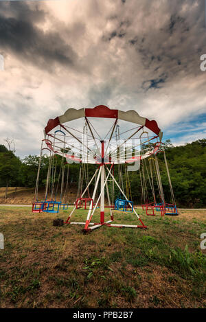 Alten, verlassenen Karussell mit Stühlen. Merry-go-round in der Landschaft Stockfoto