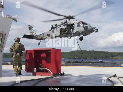 Segler für die Beseitigung von Explosivstoffen Mobile Einheit (EODMU) 5, Hubschrauber Meer Combat Squadron 25 und Australische Soldaten verhalten besuchen, Board, Durchsuchung und Beschlagnahme Operationen an Bord der maritimen Vorpositionierung ship USNS 1st Lieutenant Jack Lummus (T-AK 3011) während der Ausbildung "Pyrocrab' bei Apra Harbor, Guam, 15 August, 2018. Pyrocrab ist eine Biennale Ebene der Ausbildung, die auf die Stärkung der Beziehungen und die Verbesserung der Interoperabilität zwischen der U.S. Navy und der australischen Streitkräfte konzentriert. EODMU-5 ist zum Kommandanten, Task Force 75, die primäre Expeditionary task force Speichereinbauort zugeordnet Stockfoto