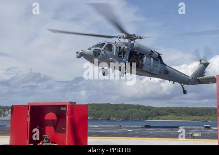 Segler für die Beseitigung von Explosivstoffen Mobile Einheit (EODMU) 5, Hubschrauber Meer Combat Squadron 25 und Australische Soldaten verhalten besuchen, Board, Durchsuchung und Beschlagnahme Operationen an Bord der maritimen Vorpositionierung ship USNS 1st Lieutenant Jack Lummus (T-AK 3011) während der Ausbildung "Pyrocrab' bei Apra Harbor, Guam, 15 August, 2018. Pyrocrab ist eine Biennale Ebene der Ausbildung, die auf die Stärkung der Beziehungen und die Verbesserung der Interoperabilität zwischen der U.S. Navy und der australischen Streitkräfte konzentriert. EODMU-5 ist zum Kommandanten, Task Force 75, die primäre Expeditionary task force Speichereinbauort zugeordnet Stockfoto