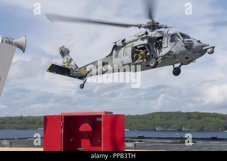 Segler für die Beseitigung von Explosivstoffen Mobile Einheit (EODMU) 5, Hubschrauber Meer Combat Squadron 25 und Australische Soldaten verhalten besuchen, Board, Durchsuchung und Beschlagnahme Operationen an Bord der maritimen Vorpositionierung ship USNS 1st Lieutenant Jack Lummus (T-AK 3011) während der Ausbildung "Pyrocrab' bei Apra Harbor, Guam, 15 August, 2018. Pyrocrab ist eine Biennale Ebene der Ausbildung, die auf die Stärkung der Beziehungen und die Verbesserung der Interoperabilität zwischen der U.S. Navy und der australischen Streitkräfte konzentriert. EODMU-5 ist zum Kommandanten, Task Force 75, die primäre Expeditionary task force Speichereinbauort zugeordnet Stockfoto