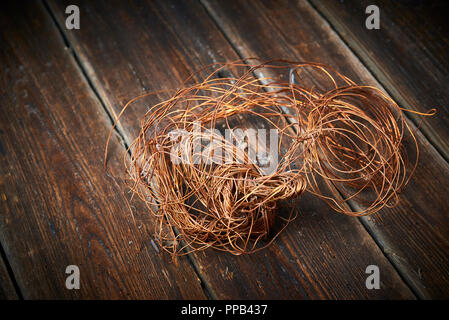 Zerknitterte Kupferdraht auf einem alten Holz- Board. Selektiver Fokus Stockfoto