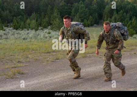 Spc. John Mundey, Armee-reservesoldat 2018 des Jahres, und Sgt. Chase Craig, 2018 Armee finden NCO des Jahres, tragen ihre Rucks auf einem 12 Kilometer Fußmarsch in die Elkhorn Mountain Range, Montana, Aug 16 2018. Die 2018 Armee finden besten Krieger und Armee finden Drill Sergeants des Jahres für drei Wochen in Montana trainiert für ihre bevorstehenden Wettkämpfe vorzubereiten. Stockfoto