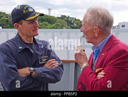 YOKOSUKA, Japan (August 17, 2018) - US 7 Flotte Flaggschiff USS Blue Ridge (LCC 19) Kommandierender Offizier Brett E. Crozier mit Ehrenmedaille Empfänger Generalmajor (A.D.) James E. Livingston während einer Moral Wohlfahrt und World Tour an Bord des Schiffes spricht. Livingston war die Ehrenmedaille für seine heroische Aktionen während der Schlacht in der Vietnam Krieg verliehen und verbrachte Zeit an Bord Blue Ridge nach dem Notfall Evakuierung von Saigon im Jahre 1975. Stockfoto