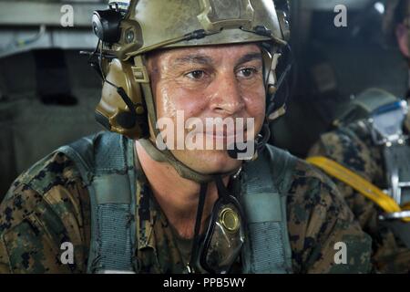 Master Sgt. Gabriel Machado bereitet sich auf den Start beim Fallschirm- und Luftzufuhr Training Operations Aug 14, 2018 at Ie Shima, Okinawa, Japan. Machado diente, wie der Assistent jumpmaster während der Ausbildung, in Kontakt mit der Crew in der CH-53E Super Stallion Hubschrauber, während die Weiterleitung von Informationen an die jumpmaster. Das Training bestand aus Low-level-statische Linie und militärischen freien Fall springt auf 10.000 Fuß um die Marines beherrschen als Fallschirm rigger/Air Delivery Spezialisten zu halten. Machado, ein Eingeborener von New York, New York, ist die Luft, die Lieferung Chief mit Landung-Support Stockfoto