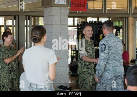 Us-Marine Kapitän John Givens, die ältere Schwester der Exekutive für Auslandseinsätze medizinische Einrichtung Dallas 1, stellt eine Herausforderung dar, Münze, US Air Force Senior Master Sgt. James Wright, der Betriebsleiter des 181St Intelligenz Flügel, in dem Mitchell Pauole Community Center in Molokai, Hi., Aug 16., 2018. Tropic Care Maui County 2018 ist eine gemeinsame - Service Innovative Readiness Training Mission von der Air National Guard geführt und durch Mitglieder der Luftwaffe, Heer, Marine Reserve unterstützt, und Marine Corps finden. Stockfoto