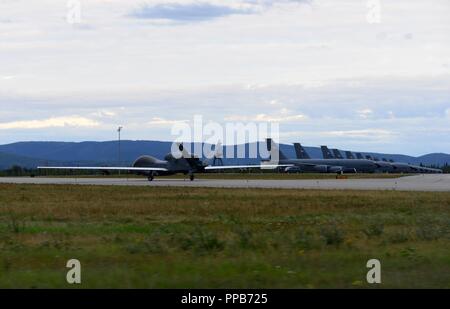 Ein RQ-4 Global Hawk, dem 12 Reconnaissance Squadron zugeordnet, Taxis durch eine Flotte von KC-135 Stratotankers während der roten Flagge Alaska 18-3, 12.08.16, 2018, at Eielson Air Force Base, Alaska. Diese Wiederholung der Übung verfügt über mehr als 100 Flugzeuge, aus mehr als ein Dutzend Einheiten aus den Vereinigten Staaten, Australien, Kanada und Großbritannien. Stockfoto