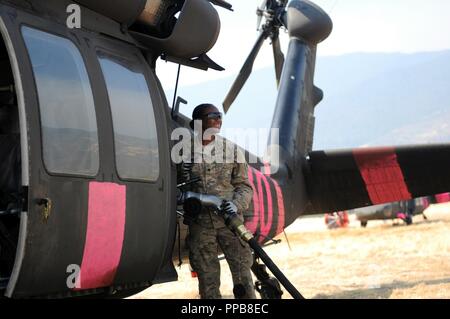 Spc. Joenetta Benjamin, fueler in die 646Th Aviation Support Battalion, Oklahoma Army National Guard zugeordnet, betankt Ein UH-60 Black Hawk Kampf gegen Waldbrände in Mendocino komplizierte Feuer, Aug 16th, 2018 at Elk Creek, Kalifornien im August 18, hat das Feuer mehr als 380.000 Hektar verbrannt. (Armee Stockfoto
