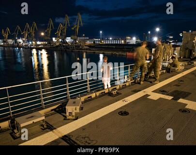 Georgien (Aug. 18, 2018) US-Armee Soldaten zu Bravo Company, 2nd Battalion, 5th Cavalry Regiment, 1st Armored Brigade Combat Team, 1.Kavallerie Division zusehen, wie die speerspitze-Klasse expeditionary schnellen Transport ship USNS Carson City (T-EPF 7) fährt Poti, Georgien, Nov. 18, 2018 zugeordnet. Carson City ist die siebte von neun Expeditionary schnellen Transport von Schiffen im Bestand Military Sealift Command mit einem primären Mission des Zur schnellen Transport von militärischem Gerät und Personal in Theater über seine 20.000-Quadratfuß-Rekonfigurierbaren Mission Bay Area und Platz für 312 Passagiere. Stockfoto