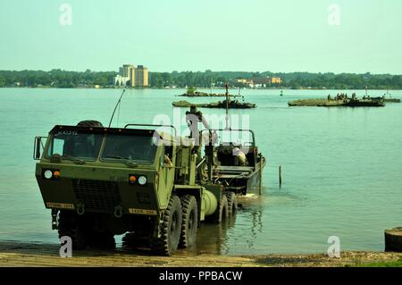 Soldaten aus der Sault Ste. Marie-basierte 1437Th Ingenieur Multi-Role Bridge Company, Michigan National Guard, bereiten Sie ein Abschnitt der verbesserten Float Brücke von der St. Marys River zu extrahieren in Sault Ste. Marie, mich mit einem M 1977 Gemeinsame Brücke schwere erweiterte Mobilität taktische Lkw, während der Brückenbau als Teil der Plan des Michigan Emergency Management Agency, am 12. August 2018 (Michigan National Guard Stockfoto