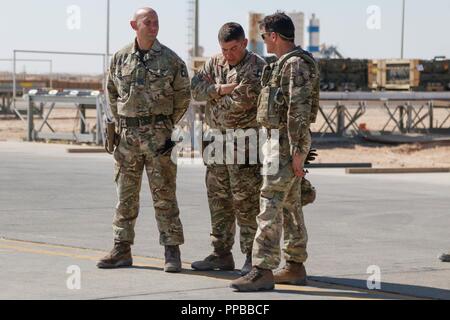 Britische Armee Maj. Neil Kendrick, Mitte, kommandierender Offizier der eine logistische Enabler Surge Team, spricht mit Generalmajor Felix Gedney, rechts, stellvertretender Kommandant der Strategie und der Unterstützung von Combined Joint Task Force - inhärenten lösen, während seiner Schlachtfeld rotation sustainment Operations bei Al Asad Air Base, Irak, Jan. 21, 2018 zu diskutieren. Stockfoto