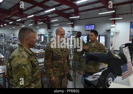 Staff Sgt. Julianno Lerma (rechts), 407 Expeditionary Force Support Squadron food service Buchhalter, erläutert die Nutzung der gemeinsamen Bewegung asset management system oder JAMMS zu oberst Scott Gibson (Mitte), 407 Air Expeditionary Gruppenkommandant und Chief Master Sgt. Markieren Umfleet, 407 AEG Betriebsleiter, während einer Tour durch die gastronomische Einrichtung als Teil eines Geschwaders Unordnung an einem unbekannten Ort in Südwestasien, 22.08.2018. JAMMS wird verwendet, um die Tausende von Flieger, Marinen, Soldaten, Matrosen, Koalitionspartner und zivile Flieger, der DFAC mehrere Male am Tag nutzen zu verfolgen. Lerma ist Stockfoto