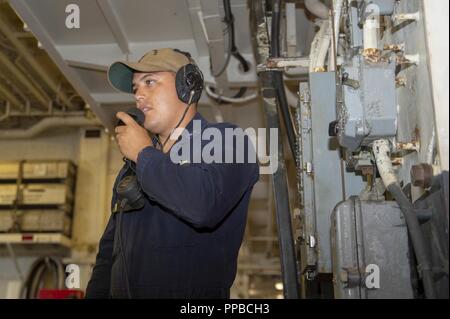 SAN DIEGO (Aug. 22, 2018) Aviation Ordnanceman 2. Klasse Meoqui Skinner, von Douglas, Ariz., kommuniziert mit Personal in einem ordnance Magazin mit einem batterielosen Telefon im Hangar Bucht des Amphibious Assault ship USS BONHOMME RICHARD (LHD6) während einer Munition entlasten. Bonhomme Richard ist in seinen Heimathafen San Diego. Stockfoto