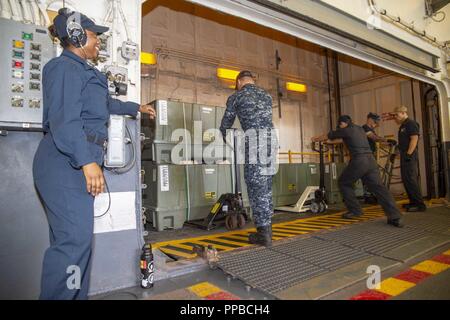 SAN DIEGO (Aug. 22, 2018) Aviation Ordnancemen Transportkisten KMU-572 Sets während einer Munition offload im Hangar Bucht des Amphibious Assault ship USS BONHOMME RICHARD (LHD6). Bonhomme Richard ist in seinen Heimathafen San Diego. Stockfoto