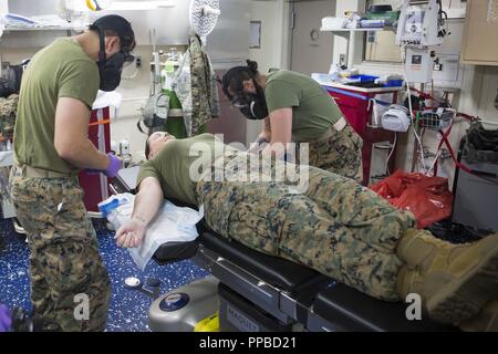 MINDANAO MEER - U.S. Navy Segler mit Combat Logistik Bataillon 13, 13 Marine Expeditionary Unit (MEU), Gas verhalten mask IV Bohrer, an Bord der San Antonio-Klasse amphibious Transport dock USS Anchorage LPD (23), die während einer planmäßigen Einsatz der Essex Amphibious Ready Group (ARG) und 13 MEU, 21. August 2018. Das Essex ARG/13 MEU ist ein fähiger und tödliche Navy-Marine Corps Team der 7 Bereich der Flotte im Einsatz der regionalen Stabilität zu unterstützen, Partner beruhigen und Verbündeten und einer Präsenz posierten auf jede Krise, die von der humanitären Hilfe zu reagieren pflegen Stockfoto