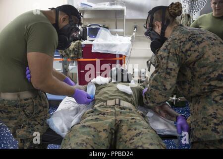 MINDANAO MEER - U.S. Navy Segler mit Combat Logistik Bataillon 13, 13 Marine Expeditionary Unit (MEU), Gas verhalten mask IV Bohrer, an Bord der San Antonio-Klasse amphibious Transport dock USS Anchorage LPD (23), die während einer planmäßigen Einsatz der Essex Amphibious Ready Group (ARG) und 13 MEU, 21. August 2018. Das Essex ARG/13 MEU ist ein fähiger und tödliche Navy-Marine Corps Team der 7 Bereich der Flotte im Einsatz der regionalen Stabilität zu unterstützen, Partner beruhigen und Verbündeten und einer Präsenz posierten auf jede Krise, die von der humanitären Hilfe zu reagieren pflegen Stockfoto