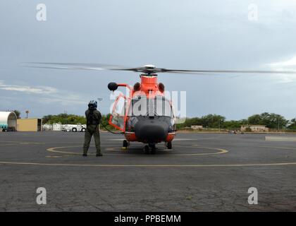 Der Küstenwache aircrew führt vor auf einem MH-65 Dolphin Hubschrauber Air Station Friseure, Hawaii, Aug 25., 2018. Die Küstenwache war die Durchführung einer Bewertung der Schäden der hawaiischen Inseln nach dem Hurrikan Lane. Stockfoto