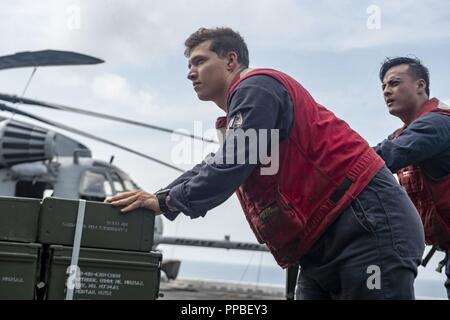 Von MALAKKA (Aug. 25, 2018) - Aviation Ordnancemen 3 Classe Mickael Delacruz und Brian Huynh transport Munition auf dem Flugdeck der Wasp-Klasse amphibisches Schiff USS Essex (LL 2), die während einer planmäßigen Einsatz der Essex Amphibious Ready Group (ARG) und 13th Marine Expeditionary Unit (MEU). Das Essex ARG/13 MEU ist ein fähiger und tödliche Navy-Marine Corps Team der 7 Bereich der Flotte im Einsatz der regionalen Stabilität zu unterstützen, Partner beruhigen und Verbündeten und einer Präsenz posierten auf jede Krise, die von der humanitären Hilfe mit kontingenz Op zu reagieren pflegen Stockfoto